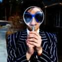 A person holding a magnifying glass.